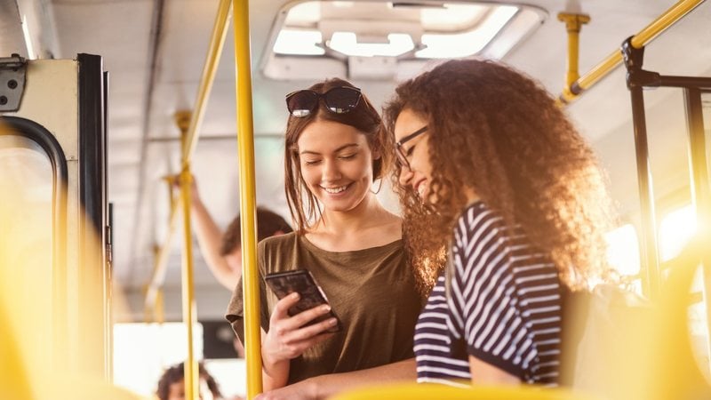 Meninas rindo lendo o celular - dusanpetkovic/iStock