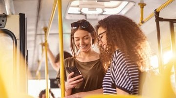 Meninas rindo lendo o celular - dusanpetkovic/iStock