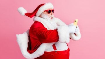 Papai Noel mexendo no celular - Deagreez/iStock