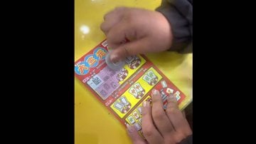 Jovem raspando uma cartela de loteria - Via TikTok/@aiaihong