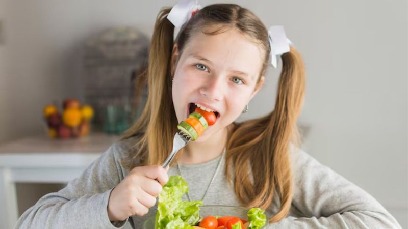 Criança comendo salada