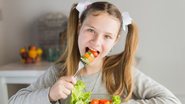 Criança comendo salada