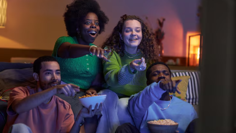 amigos sentados comendo pipoca, se divertindo e vendo filme