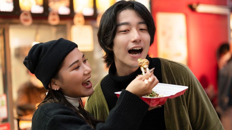 Mulher dando comida na boca do namorado