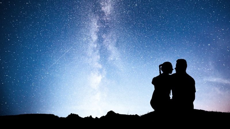 Casal ao ar livre em noite estrelada