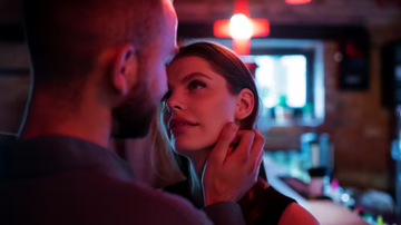 casal flertando em ambiente com luz baixa