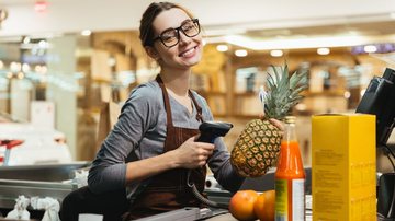 Mulher passando as compras no caixa
