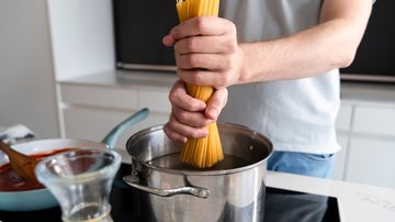 Homem cozinhando macarrão