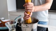 Homem cozinhando macarrão