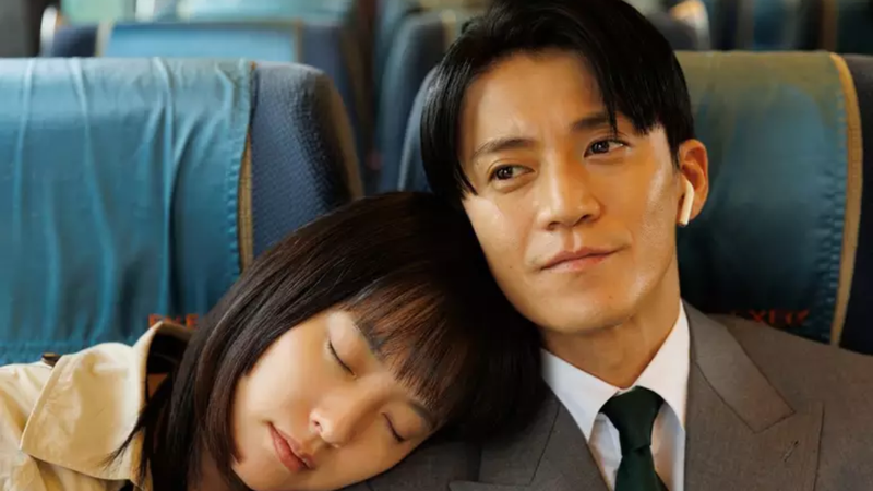 protagonistas da série sentados em transporte, com a moça encostando sua cabeça no ombro do homem.