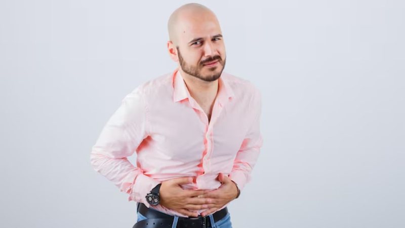 homem com mãos sob o abdômen