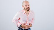 homem com mãos sob o abdômen