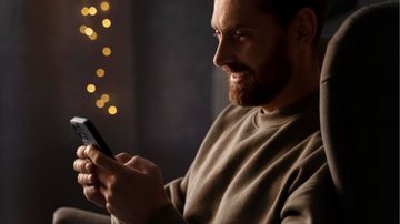 Homem enviando mensagens de texto e sorrindo