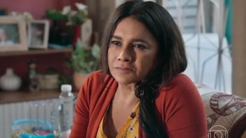 Mulher sentada no sofá e demonstrando grande emoção