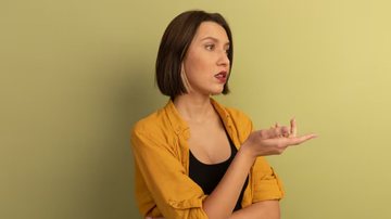 Mulher vestida de amarelo e preto discutindo