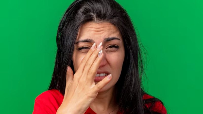 mulher incomodada com as mãos no rosto