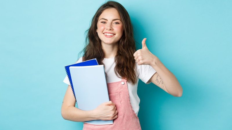 Estudante preparada para o enem fazendo sinal positivo com o dedo