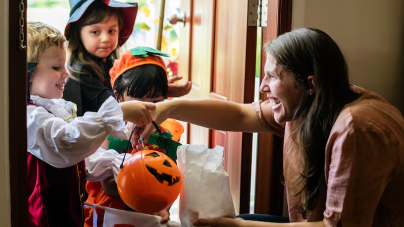 crianças fantasiadas pegando doces durante o halloween na vizinhança