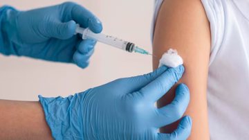 aplicando vacina no braço de paciente