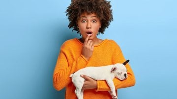 mulher assustada segurando cachorrinho filhote no colo