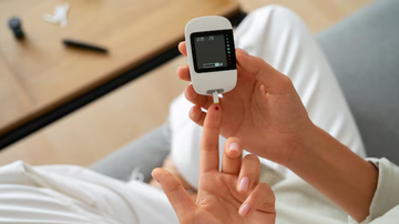 Indivíduo usando dispositivo para medir insulina no sangue.