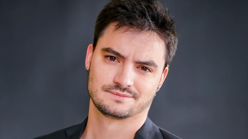 Felipe neto, posando sobre fundo escuro e desfocado.