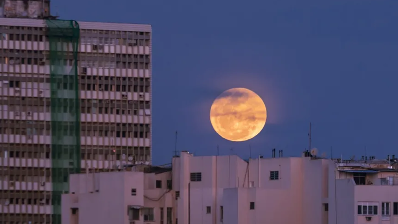 Superlua vermelha fotografada entre prédios.