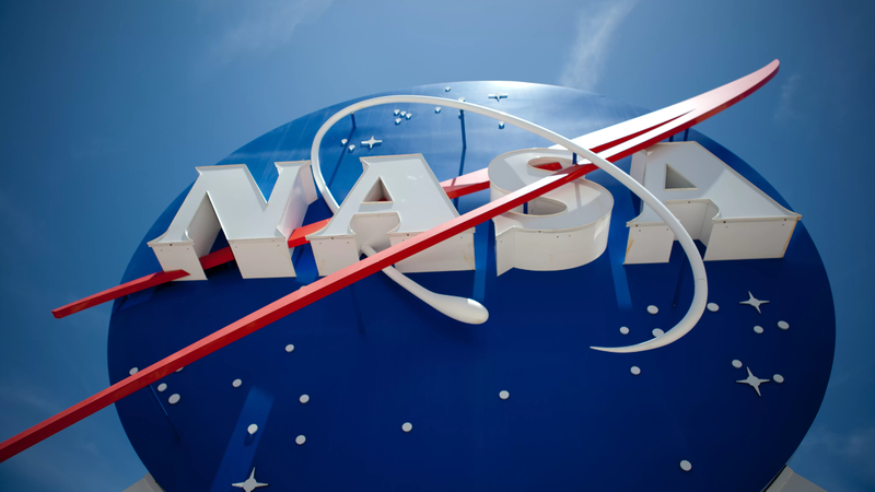 Logo da Nasa, fotografado debaixo sob fundo de céu azul.