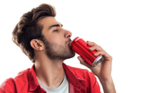 Homem tomando refrigerante em lata sob fundo branco.