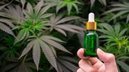 Frasco de vidro em meio à folhas de cannabis.