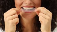 Mulher usando fita de clareamento dental.