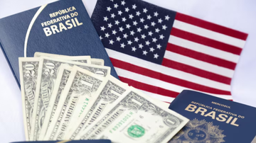 Passaporte brasileiro ao lado de bandeira dos EUA.