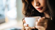 Mulher com xícara de café em mãos.