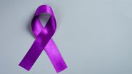 laço roxo sob fundo cinza.