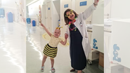 Criança e sua médica se divertindo em hospital.