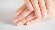 Mulher com unhas naturais longas.