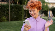 Mulher com aparelho celular nas mãos enviando mensagem e sorrindo