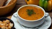 Bowl com caldo, ao lado de bowl com torradas cortadas em cubos.