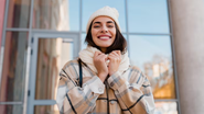 mulher usando casacos e sorrindo durante dia frio.