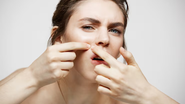 mulher espremendo espinha no rosto na região do bigode