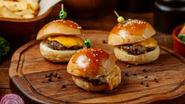 mini hambúrgueres espetados sob mesa.