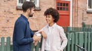 homem e mulher conversando em ambiente aberto, encostados em cerca.