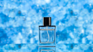 Perfume aquático sob fundo azul.