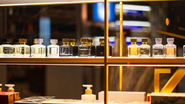 perfumes dispostos em fileira em uma prateleira.