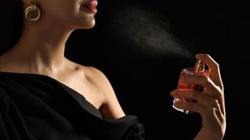 mulher borrifando perfume
