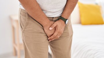 homem com fita metrica e expressão assustada