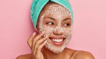 mulher sorridente com esfoliante no rosto.