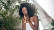 mulher com frasco de perfume na mão