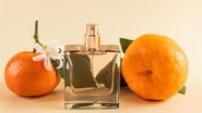 perfume frutado ao lado de duas laranjas.