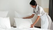 mulher trocando roupa de cama.
